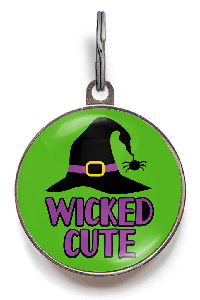 Green Halloween dog tag with black witch hat, spider and text “Wicked Cute”