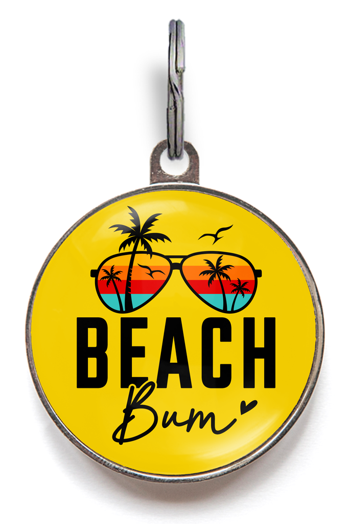 Beach Bum Pet ID Tag - Dog tag with yellow background featuring sunglasses reflecting palm trees against a sunset, with the words Beach Bum in a black font